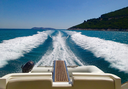 Yacht trail on deep blue sea water surface behind the fast moving boat