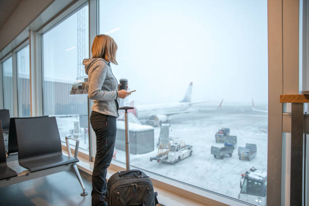 mujer de pie cerca de la ventana en el aeropuerto - norte de noruega fotografías e imágenes de stock