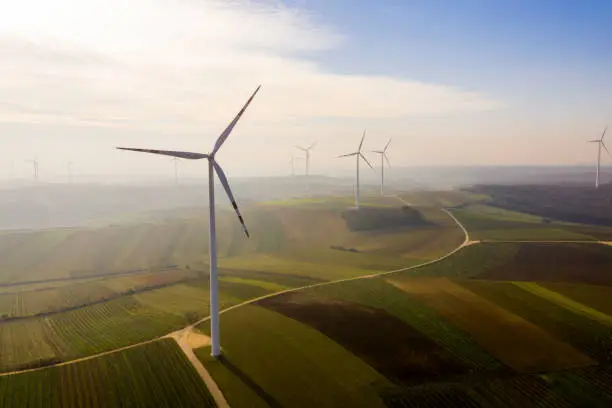 Aerial view of wind turbine under moody sky on fields