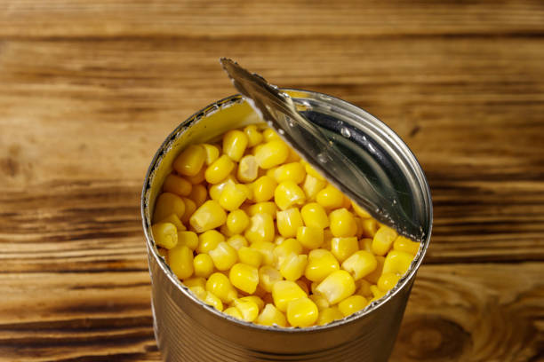 istock Open tin can of corn on wooden table 1094639726
