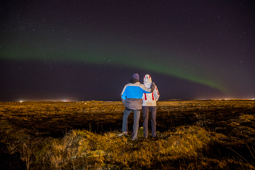 Rear view of a couple watching aurora borealis at night,Iceland