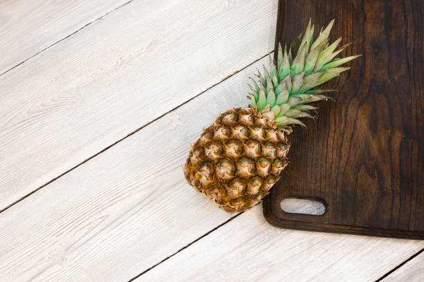 istock Fresh ripe pineapple on a white wooden background, top view. From above 1094643192