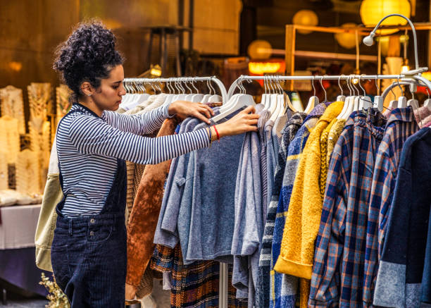 Hispanic young woman looking and choosing for garment is a store