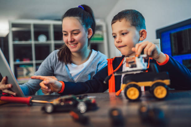 istock Happy smiling boy and girl constructs technical toy. Technical toy on table full of details 1094646144