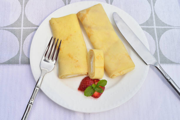 crêpes, filled with cream cheese, served with fresh strawberry