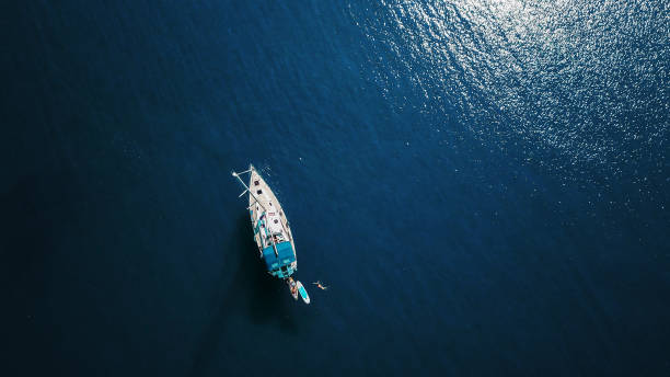 foto aérea de bela lagoa azul, em dia quente de verão, com o barco à vela. vista superior. - mergulhar para o chão - fotografias e filmes do acervo