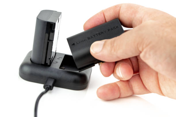 istock Man manipulating Camera battery and charger 1094656972