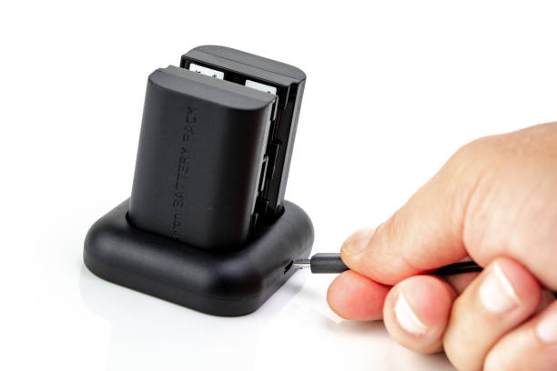istock Man manipulating Camera battery and charger 1094656976