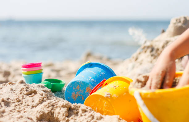 istock a child is playing with a plastic bucket at the beach 1094658494