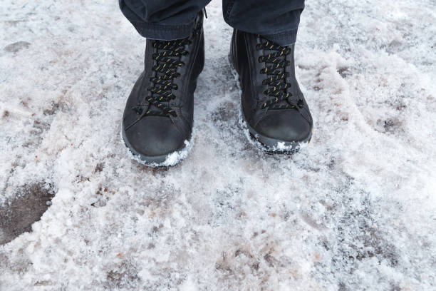 istock Male feet in boots standing in snow 1094665834
