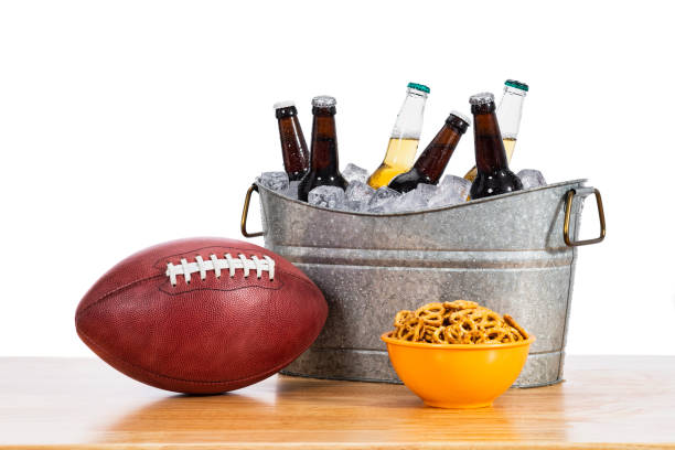 an american football with a tub of beer bottles and a bowl of pretzels - american football football food snack imagens e fotografias de stock