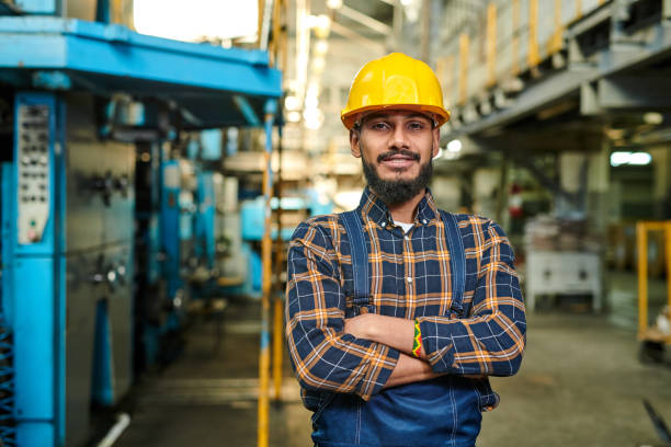 istock Content confident young middle-eastern engineer with beard standing in factory workshop and smiling at camera while crossing arms on chest 1094669850