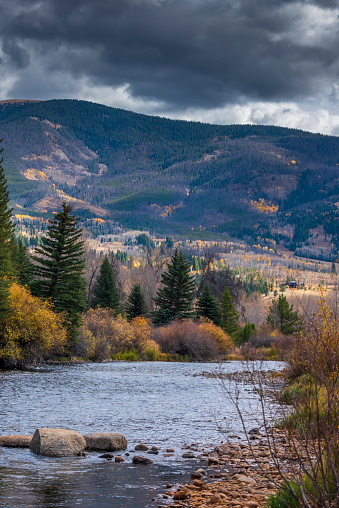 Storm clouds gather over the Blue Rive in Silverthorne, Summit County, Colorado.  Image captured in the fall.  The clouds look ominous.