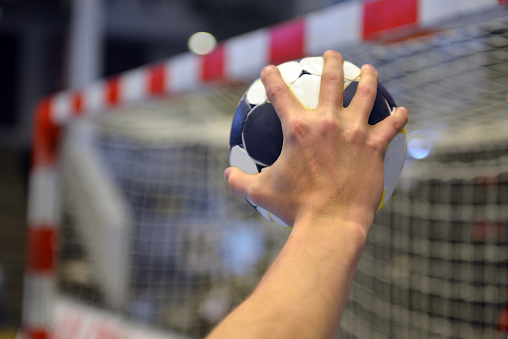 Handball Player with a handball  about to throw the ball into the goal