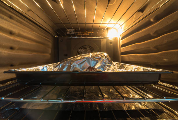 istock closeup view raw beef cross rib chunk covered with cooking foil on tray inside oven 1094683894