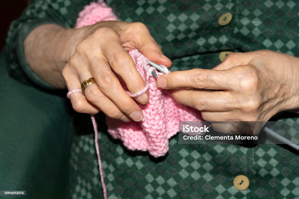Old woman Knitting at home. Old woman Knitting pink wool at home. Lifestyle concept Adult Stock Photo