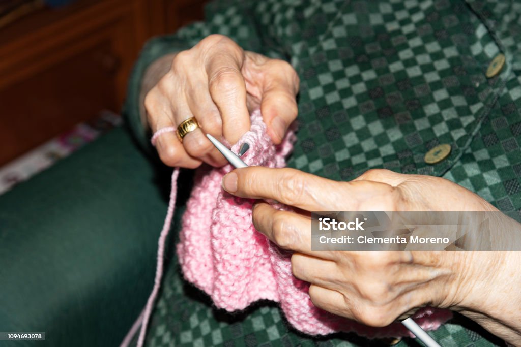 Old woman Knitting at home. Old woman Knitting pink wool at home. Lifestyle concept Adult Stock Photo