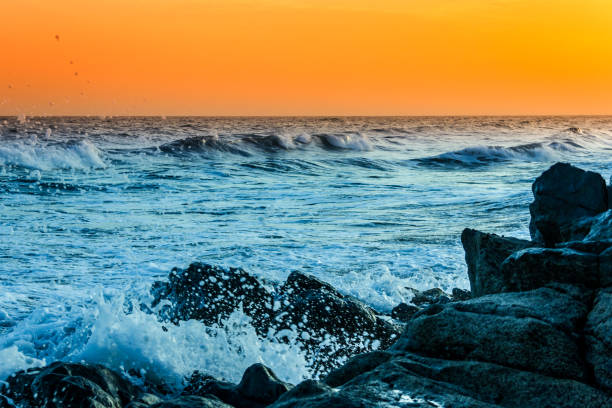 istock Wild waves splashing on rocks at sunset 1094700466