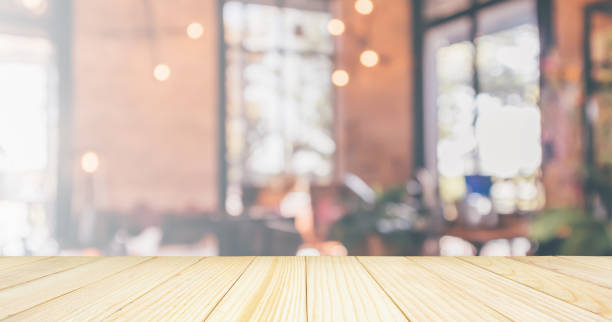istock Empty Wood table top with Restaurant cafe or coffee shop interior with customer blur abstract vintage style bokeh light for montage product display background 1094708380