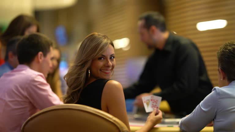 Beautiful woman on a lucky strike at the casino playing blackjack looking at camera smiling