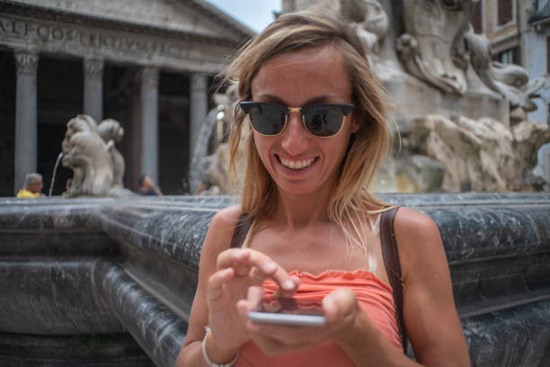istock Woman text messaging on mobile phone, Pantheon, Rome, Italy 1094712956