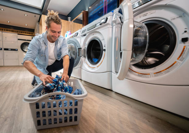 istock Latin american young man loading washing machine at a laundromat smiling 1094713418