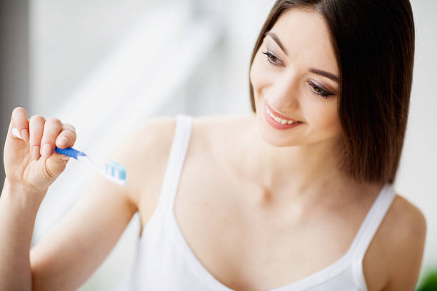 istock Beautiful Smiling Woman Brushing Healthy White Teeth With Brush. High Resolution Image 1094721532