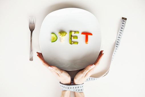 Diet or weight control concept. Centimeter tape and fork on a white background with a place for inserting text. concept of health, weight loss, diet, proper nutrition.