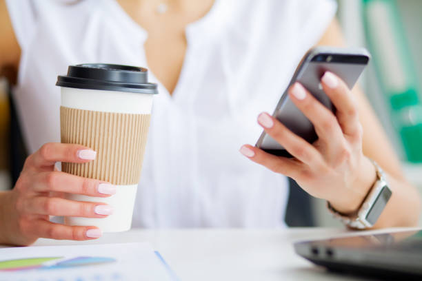 istock Young woman using her phone and drink coffee in office 1094722054