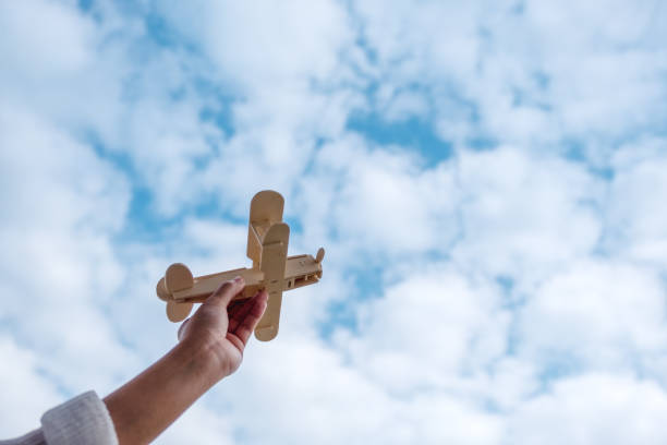 istock A hand holding and rising a wooden airplane 1094730332