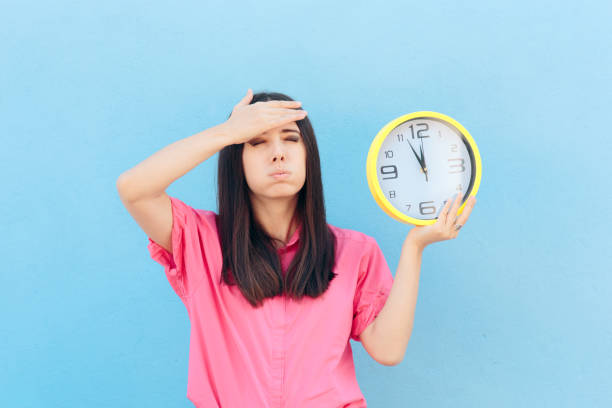 istock Forgetful Woman Holding a Clock on a Blue Background 1094733630