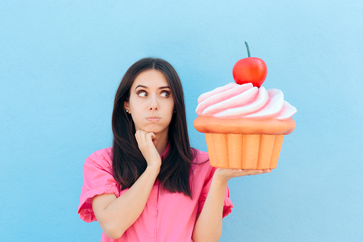 Woman holding big backed dessert on cheat day