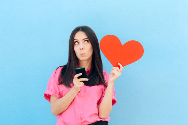 женщина холдинг смартфон поиск интернет любовь онлайн - flirting humor valentines day love стоковые фото и изображения