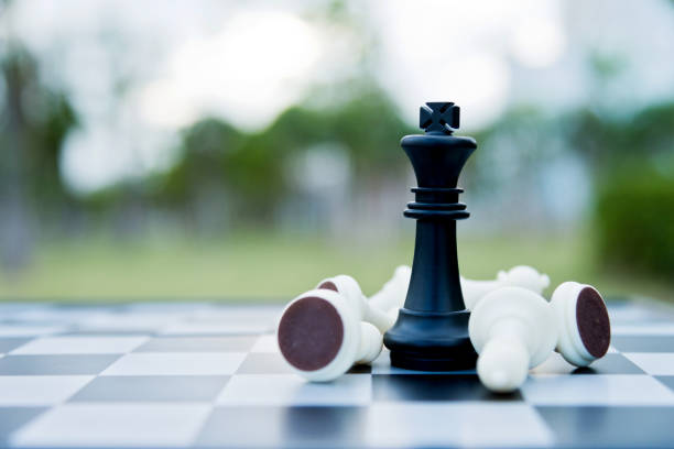 istock Black chess king among lying down white pawns 1094744002