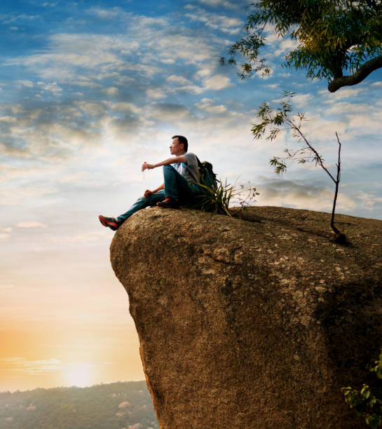 istock Hiking man sitting on the rock drinking water 1094751320