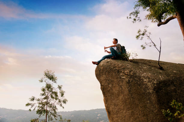 istock Hiking man sitting on the rock drinking water 1094751334
