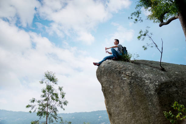 istock Hiking man sitting on the rock drinking water 1094751348