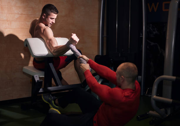 istock two strong man, exercising, one pushing others arm with towel. 1094753402