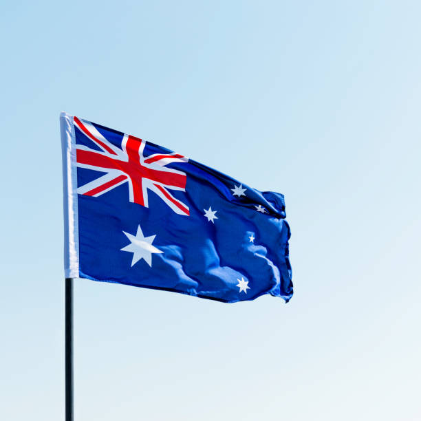 istock Waving Australia flag against blue sky 1094760896