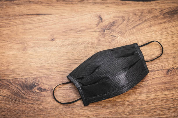 Pollution mask on wooden background. Black mask for wearing.