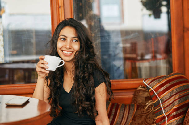 istock young Arabic woman drinking coffee at a cafe 1094761406