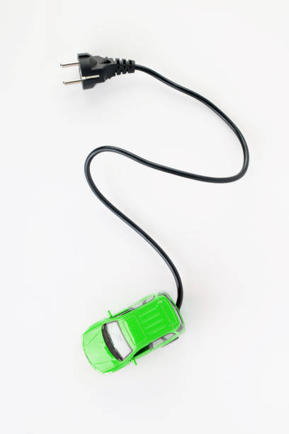 Green  electric car  with electric plug on white background