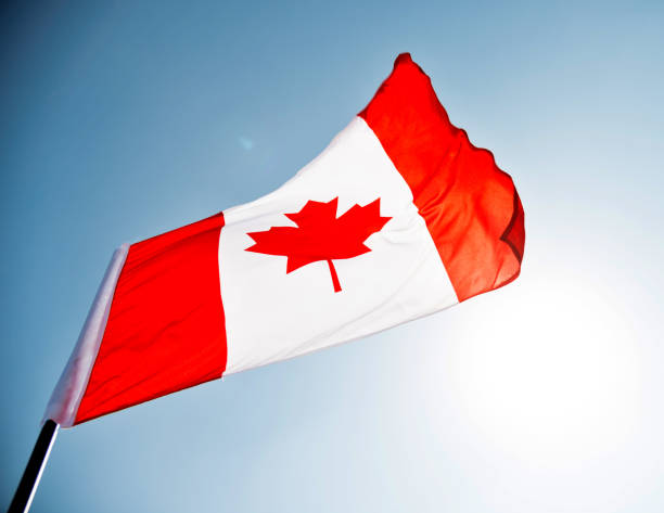 istock Canadian flag waving  against clear blue sky 1094764338