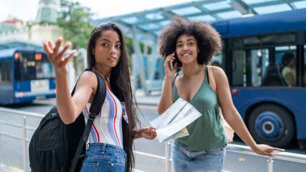 istock Smiling girlfriends standing on street and looking for direction 1094765928
