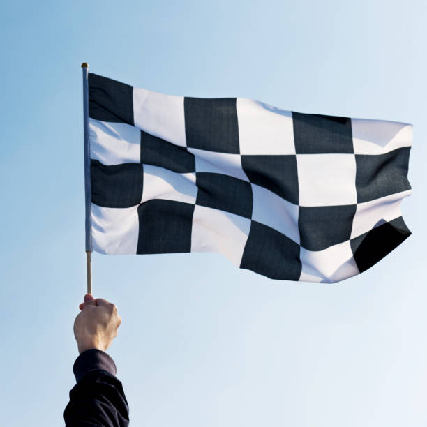istock Man hand holding checkered flag in the wind 1094767404