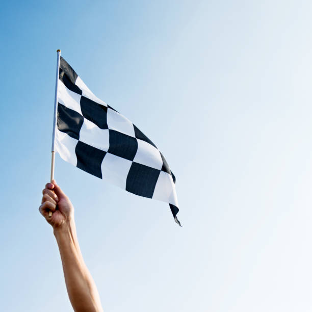 istock Man hand holding checkered flag in the wind 1094767422