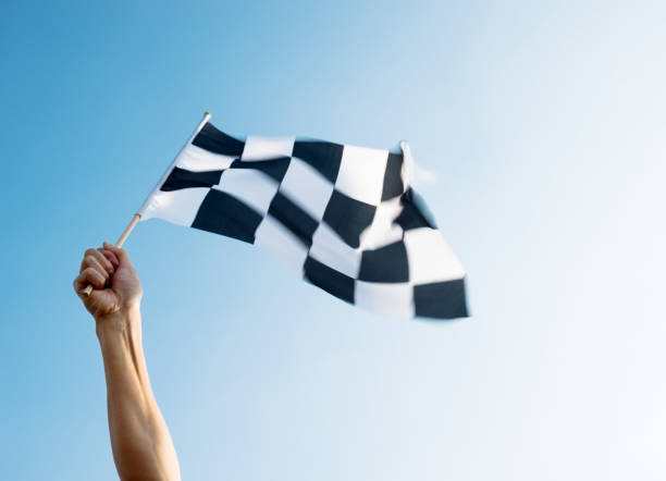 istock Man hand holding checkered flag in the wind 1094767426
