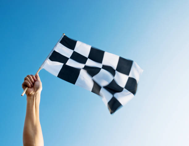 istock Man hand holding checkered flag in the wind 1094767440