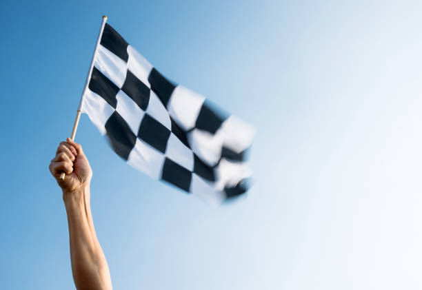 istock Man hand holding checkered flag in the wind 1094767454
