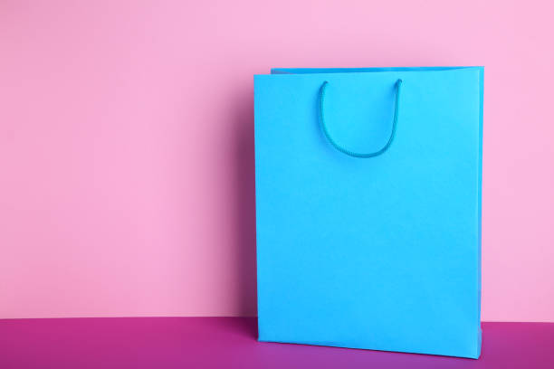 istock Blue paper shopping bag on pink background 1094775192